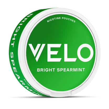 Sobre fondo blanco se muestra un envase redondo verde Bright Spearmint de VELO con "Nicotina mentolada" sobre el nombre de la marca y los ingredientes de origen vegetal resaltados.