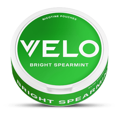 Un envase redondo verde VELO Bright Spearmint con letras blancas llamativas, que contiene bolsitas Slim Format de nicotina mentolada elaboradas con ingredientes de origen vegetal.