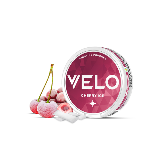 Se muestra un envase abierto de VELO Cherry Ice, con dos bolsitas blancas a su lado sobre una superficie blanca, destacando una irresistible experiencia de nicotina de cereza helada.