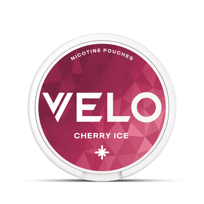 Un envase redondo de bolsitas de nicotina VELO Cherry Ice presenta un diseño geométrico rosa y rojo. La tapa muestra las BOLSITAS DE NICOTINA y VELO CHERRY ICE, ofreciendo una refrescante experiencia de nicotina con notas de cereza.