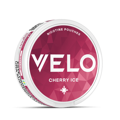 El envase redondo blanco de VELO Cherry Ice se asienta sobre un fondo geométrico rosa, su tapa presenta un texto blanco en negrita y sugiere una refrescante experiencia de nicotina con notas de cereza y cítricos frescos.
