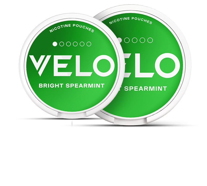 Dos latas verdes redondas de bolsitas de nicotina VELO Bright Spearmint, etiquetadas MINI (12 x 30 mm) y SLIM (70 x 70 mm), superpuestas sobre fondo blanco.