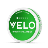Un envase redondo de bolsitas de nicotina VELO Bright Spearmint con una etiqueta verde y blanca, que muestra el nombre de la marca y el sabor en la tapa.