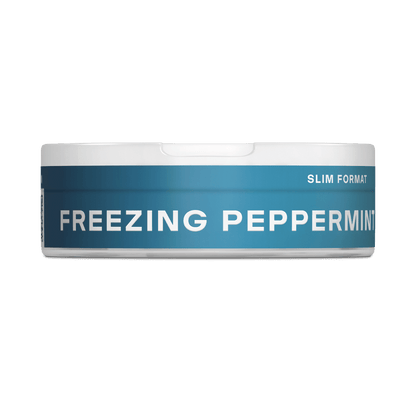 Un envase VELO redondo y blanco con una etiqueta azul "FREEZING PEPPERMINT" y "SLIM FORMAT" en texto blanco se muestra de perfil sobre un fondo blanco liso, resaltando su intenso sabor a menta.