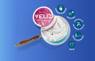 Una lata de sobres de nicotina VELO Watermelon Ice se muestra bajo una lupa, resaltando los sobres. Los iconos alrededor de la lata enumeran los ingredientes: aromas, nicotina, materiales vegetales, edulcorantes y agua.