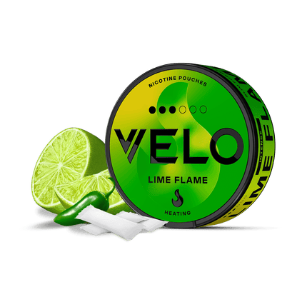 Una lata redonda verde y amarilla de VELO Lime Flame con bolsitas sensoriales de nicotina se sitúa delante, junto a una rodaja de lima y un chile verde, resaltando su atrevido sabor elaborado con ingredientes de primera calidad.