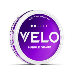 Una lata redonda y morada de bolsitas de nicotina VELO con la etiqueta Purple Grape, texto en blanco y tapa blanca, sobre un fondo blanco liso.
