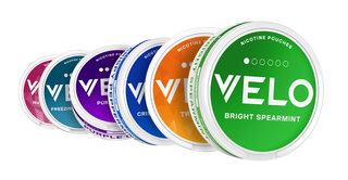 Seis envases redondos de nicotina Velo en varios colores -verde, naranja, azul, morado y blanco- están dispuestos en una línea diagonal, cada uno etiquetado con un sabor diferente, como Bright Spearmint en la parte delantera.