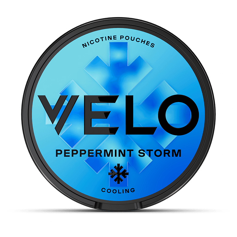 Una lata redonda de VELO Peppermint Storm con fondo azul, gráficos de cristales de hielo y texto negro en negrita. Elaborada con ingredientes de origen vegetal e intenso sabor a menta para un toque ultrafresco.