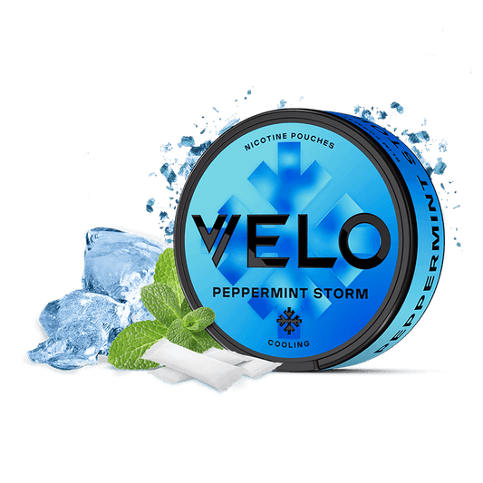 Una lata azul de VELO Peppermint Storm se encuentra junto a cubitos de hielo, hojas de menta y dos bolsitas blancas de nicotina, resaltando su intenso sabor a menta y nicotina mentolada para una sensación fresca y revitalizante.
