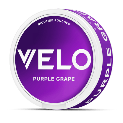 Un envase redondo blanco con una etiqueta morada que indica "VELO Purple Grape" y "Nicotine Pouches", con nicotina afrutada. En el lateral también puede leerse "Purple Grape".