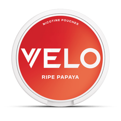 Un envase redondo blanco con una tapa rojo-naranja etiquetado VELO Papaya Madura, que contiene sobres de nicotina para una experiencia de sabor afrutado y tropical.