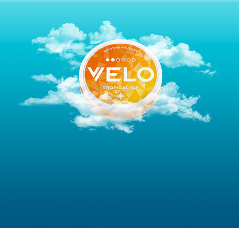 En el centro de la imagen aparece un envase redondo de nicotina VELO Tropical Ice de color naranja, rodeado de nubes blancas sobre un fondo de cielo azul degradado.