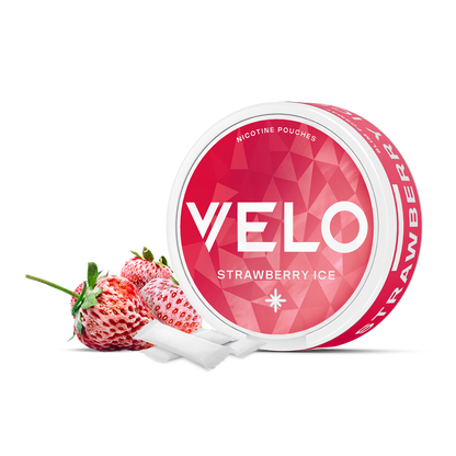 Un envase redondo de VELO Strawberry Ice con un diseño geométrico rosa y blanco se sitúa junto a fresas frescas, bolsas blancas de nicotina derramándose, destacando su sabor a fresa y una experiencia de nicotina premium.