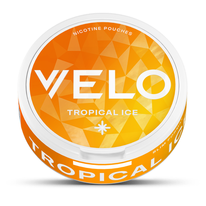 Un envase redondo y blanco de VELO Tropical Ice se asienta sobre un fondo geométrico naranja-amarillo, destacando los sabores piña, coco y mango con ingredientes de origen vegetal. En la parte superior aparece impreso "Nicotine Pouches".