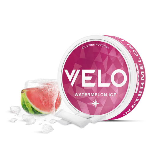 Un envase redondo de VELO Watermelon Ice junto a una rodaja de sandía con cubitos de hielo. El envase rosa, el texto en blanco y los motivos geométricos sugieren una refrescante experiencia nicotínica con sabor a sandía.