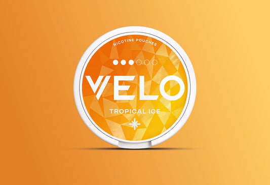 Sobre un fondo naranja degradado, un envase redondo blanco con una etiqueta naranja de motivos geométricos en la que se lee VELO Tropical Ice and Nicotine Pouches.