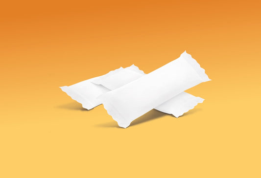 Sobre un fondo naranja degradado se disponen dos compresas rectangulares blancas en envoltorios lisos.