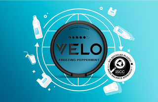 El envase azul de la bolsita de nicotina VELO Freezing Peppermint está centrado sobre un gráfico de un globo terráqueo, rodeado de elementos de plástico reciclado y un distintivo de certificación ISCC de balance de masa de plástico reciclado del 34%.