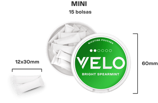 Una lata redonda abierta con la etiqueta VELO BRIGHT SPEARMINT contiene 15 bolsitas blancas de nicotina. Dimensiones mostradas: la lata mide 60 mm de ancho, cada bolsita mide 12x30 mm. El texto sobre la lata dice MINI 15 bolsas.